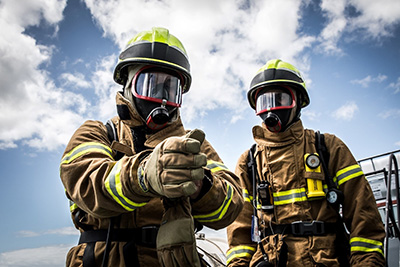 Two firefighters putting on protective gear