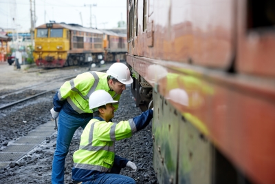 railroad workers repair train in railyard