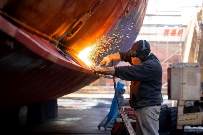 shipyard worker makes welding repairs