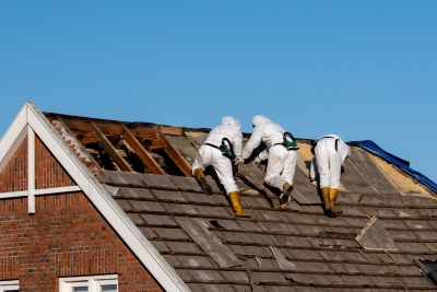 workers wearing protective gear while removing asbestos shingles